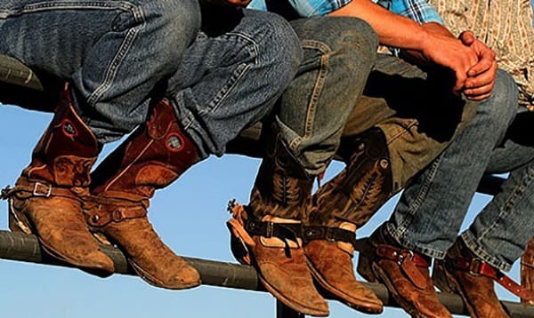 Cowboy Boots And Jeans - Cowboys sitting on fence wearing jeans and boots
